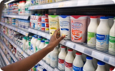 Shopper picking Danna yoghurt from a supermarket shelf